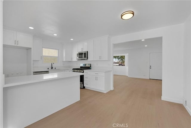 kitchen with sink, plenty of natural light, white cabinets, and appliances with stainless steel finishes