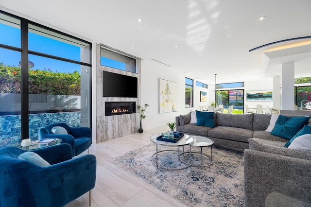 living room with a large fireplace and a wall of windows