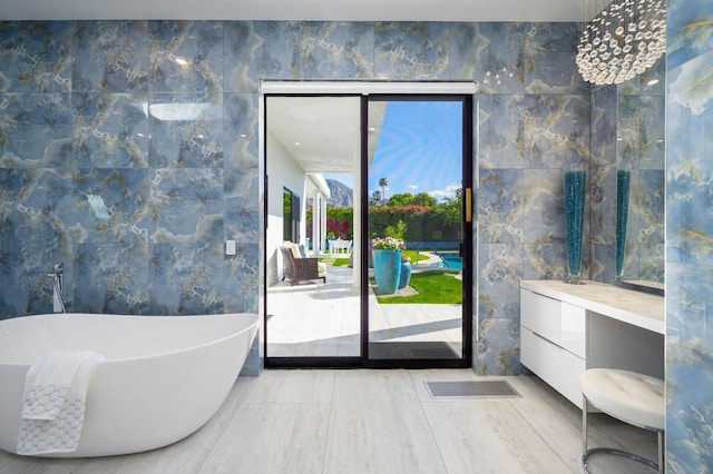 bathroom featuring vanity, tile walls, and a tub to relax in