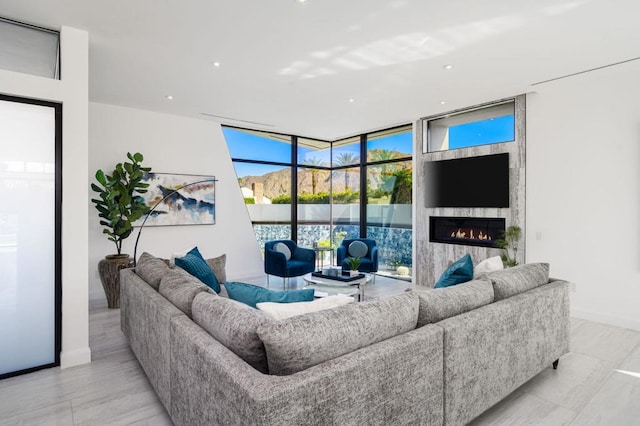 living room with a high end fireplace and floor to ceiling windows