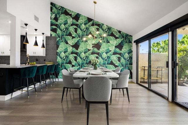 dining room featuring hardwood / wood-style floors and vaulted ceiling