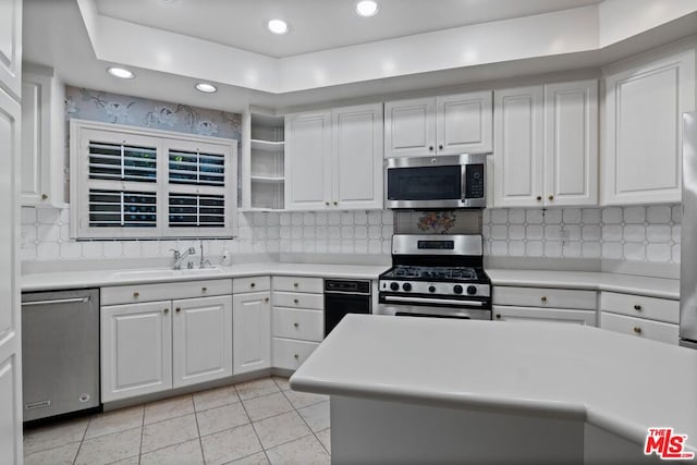 kitchen featuring sink, white cabinets, light tile patterned flooring, and appliances with stainless steel finishes