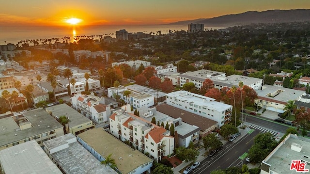 aerial view at dusk featuring a water view