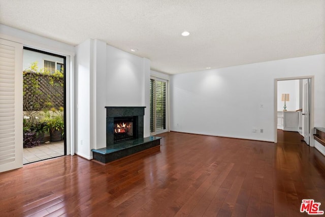 unfurnished living room with a fireplace, wood-type flooring, and a textured ceiling