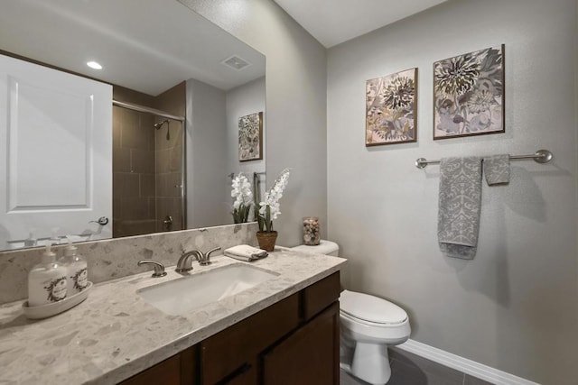 bathroom with tile patterned floors, tiled shower, vanity, and toilet