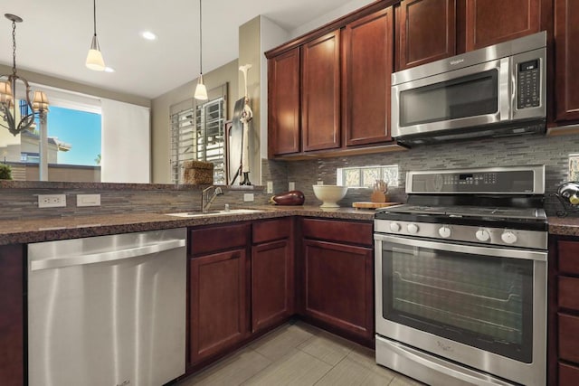 kitchen featuring backsplash, sink, hanging light fixtures, stainless steel appliances, and a chandelier