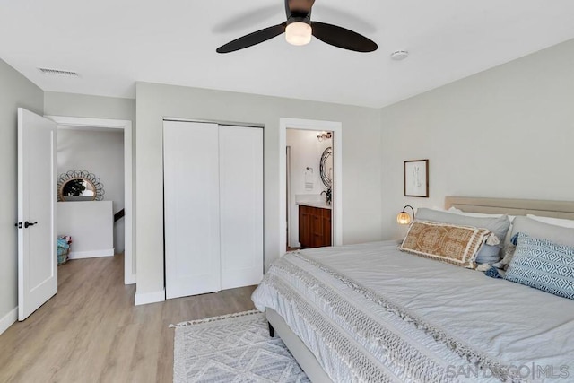 bedroom featuring a closet, ensuite bathroom, light hardwood / wood-style flooring, and ceiling fan