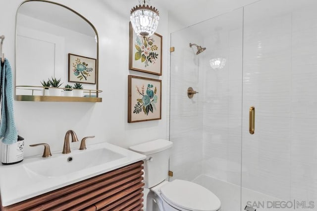 bathroom featuring vanity, toilet, and a shower with door