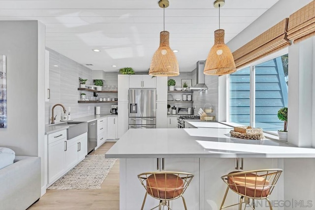 kitchen featuring white cabinets, appliances with stainless steel finishes, a breakfast bar, and plenty of natural light