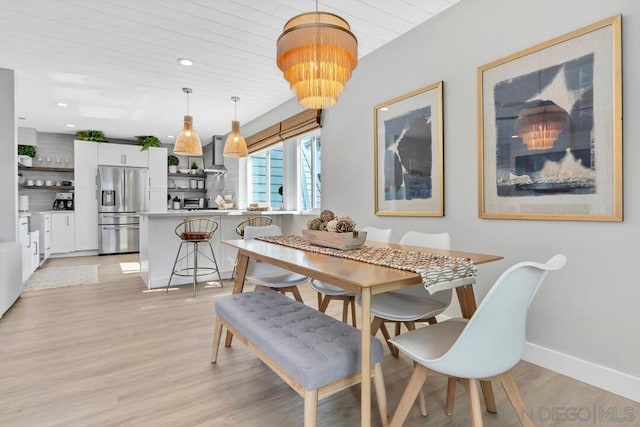 dining area with light wood-type flooring, wood ceiling, and an inviting chandelier