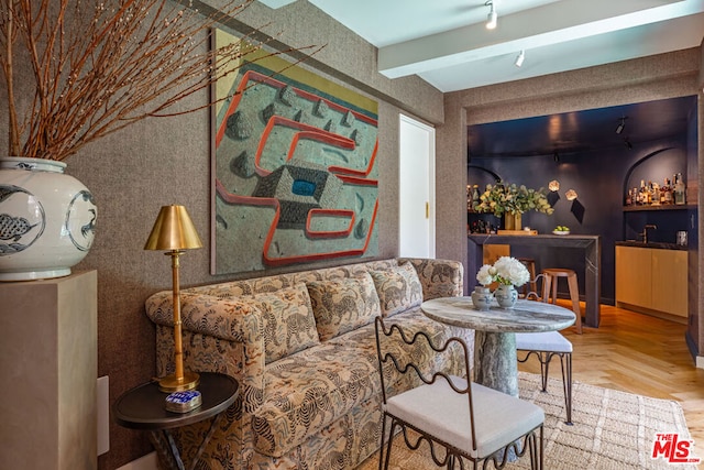 living room with beamed ceiling, parquet flooring, bar area, and track lighting