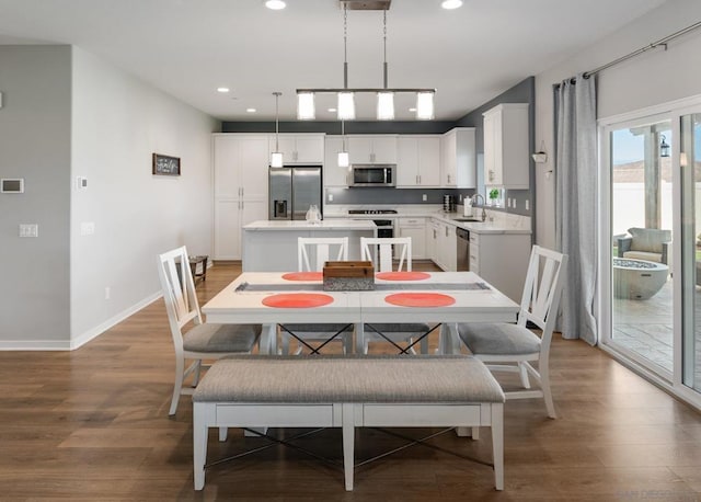 dining space with hardwood / wood-style flooring and sink