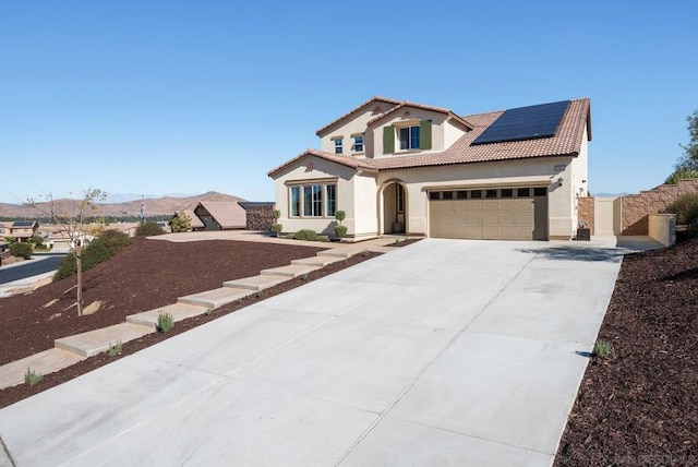 view of front of property with a mountain view and solar panels