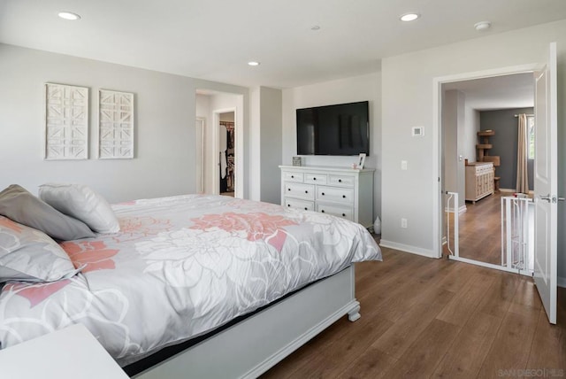 bedroom with hardwood / wood-style flooring, a spacious closet, and a closet