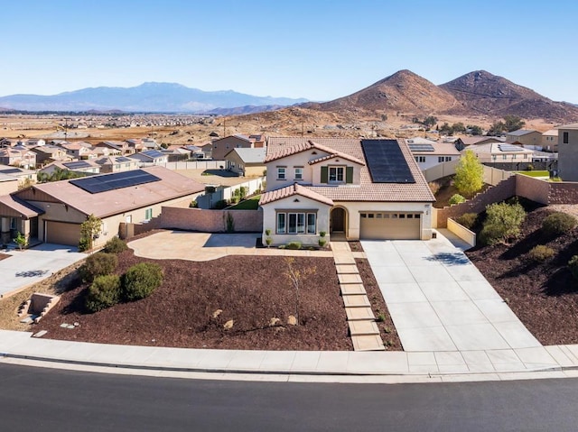 view of front of property featuring a mountain view, solar panels, and a garage