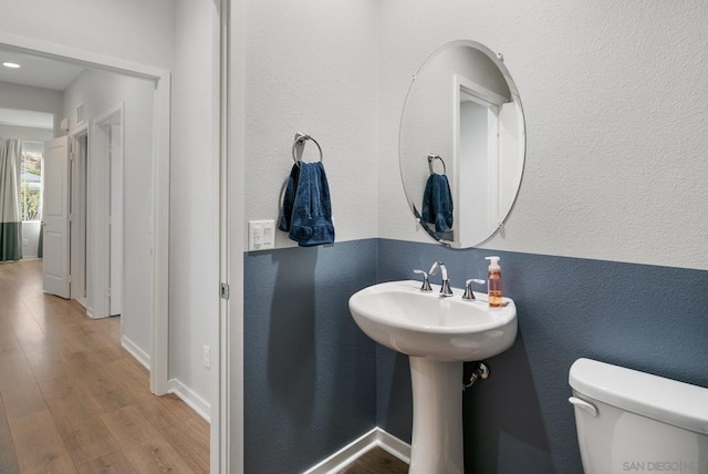 bathroom featuring hardwood / wood-style floors and toilet