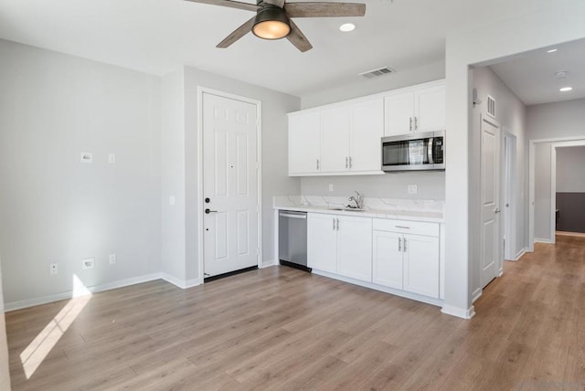 kitchen featuring ceiling fan, sink, stainless steel appliances, light hardwood / wood-style floors, and white cabinets