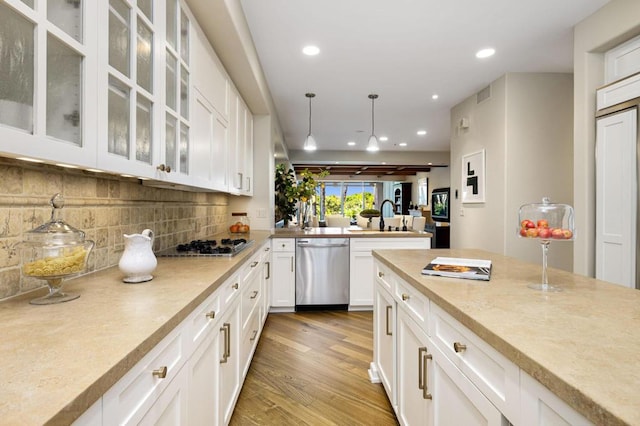 kitchen with stainless steel appliances, pendant lighting, and white cabinets