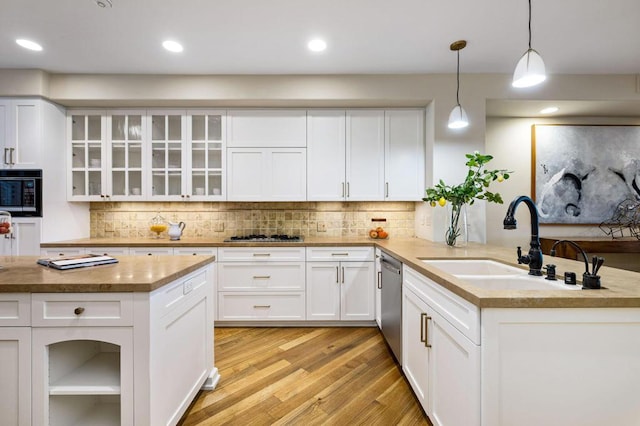 kitchen featuring decorative light fixtures, sink, white cabinetry, and stainless steel appliances