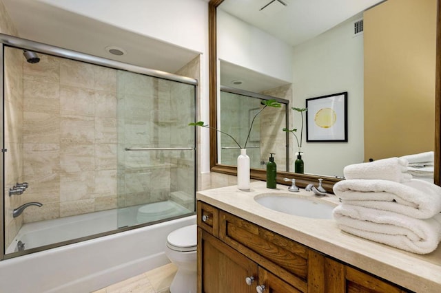 full bathroom featuring toilet, tile patterned floors, vanity, and shower / bath combination with glass door