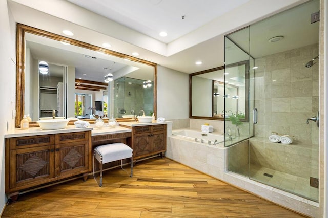 bathroom featuring hardwood / wood-style flooring, vanity, and separate shower and tub