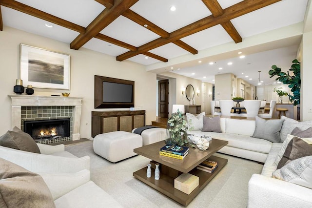 living room with a tiled fireplace, beamed ceiling, and coffered ceiling