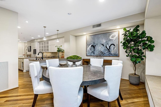 dining space with sink and light hardwood / wood-style flooring