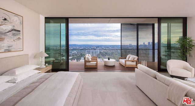 bedroom featuring carpet and a wall of windows