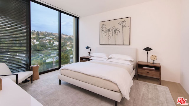 bedroom featuring light hardwood / wood-style floors and expansive windows