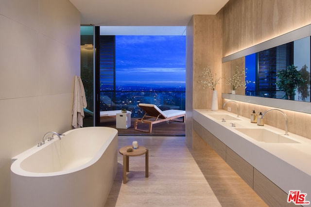 bathroom with a bath, wood-type flooring, and sink