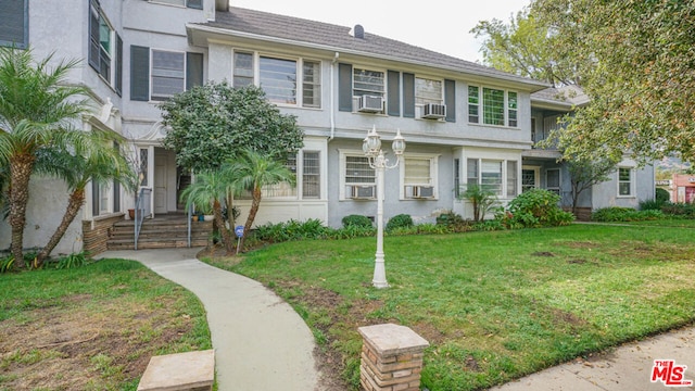 view of front facade with a front yard and cooling unit