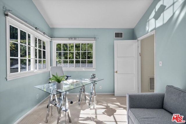 home office with light colored carpet and vaulted ceiling