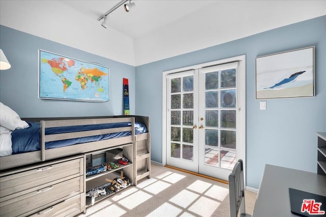 bedroom with light carpet, french doors, and track lighting