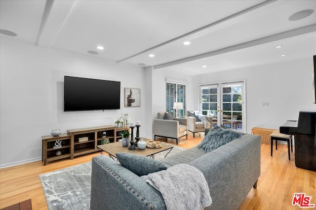 living room featuring french doors, beamed ceiling, and light hardwood / wood-style floors