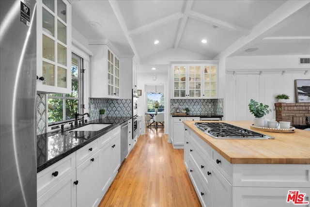 kitchen featuring butcher block counters, sink, decorative backsplash, white cabinets, and appliances with stainless steel finishes