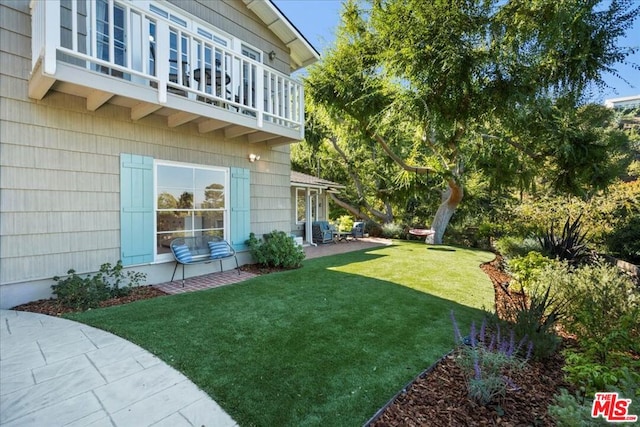 view of yard with a patio and a balcony