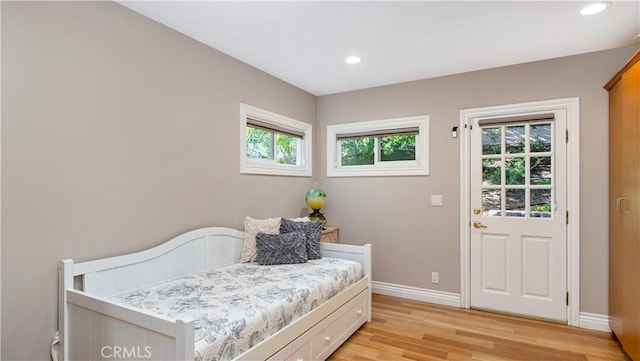 bedroom with light wood-type flooring and multiple windows