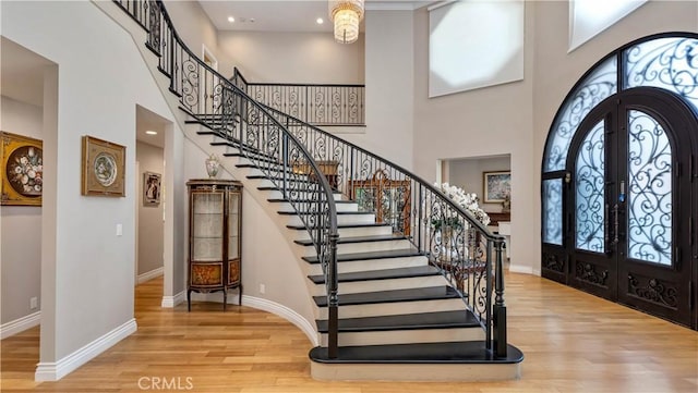 entryway featuring light hardwood / wood-style floors, a high ceiling, and french doors