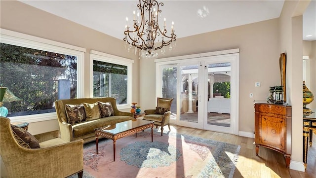 sunroom / solarium featuring a chandelier and french doors