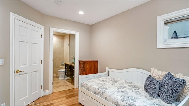 bedroom featuring light hardwood / wood-style floors and ensuite bath