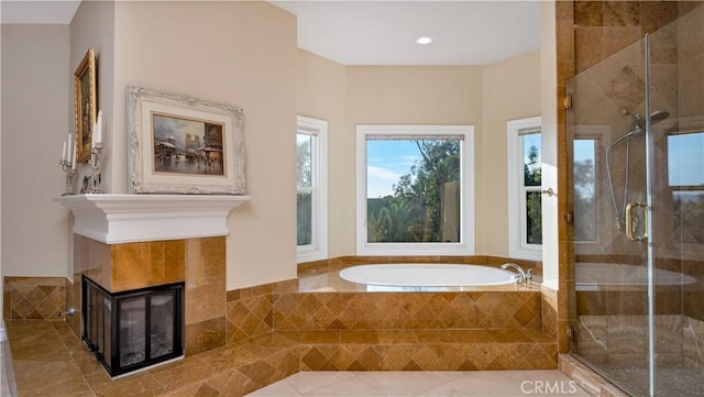 bathroom with shower with separate bathtub and a tiled fireplace