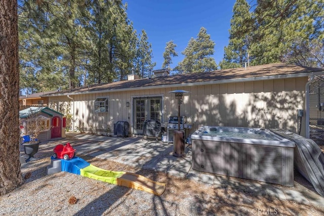 back of property with a patio area, french doors, and a hot tub