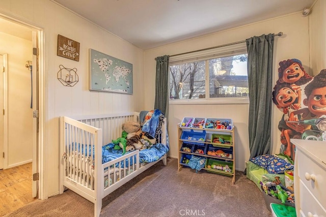 bedroom featuring a crib and hardwood / wood-style flooring