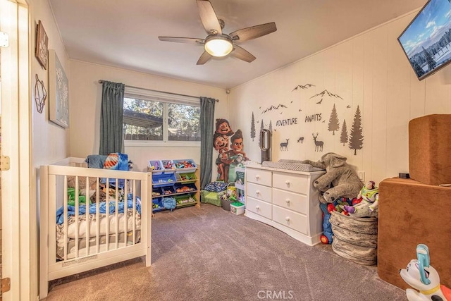 bedroom featuring ceiling fan, carpet, and a crib