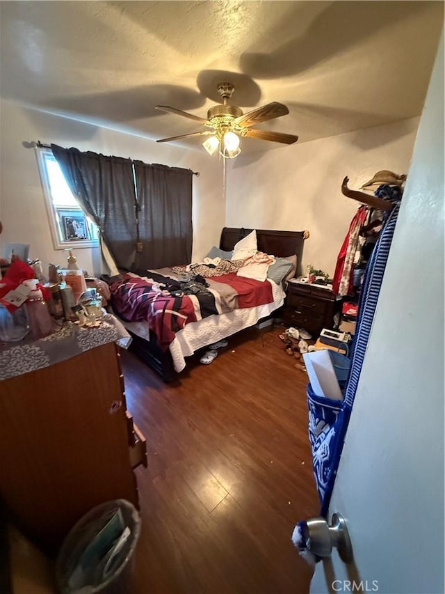 bedroom featuring a textured ceiling, dark hardwood / wood-style flooring, and ceiling fan