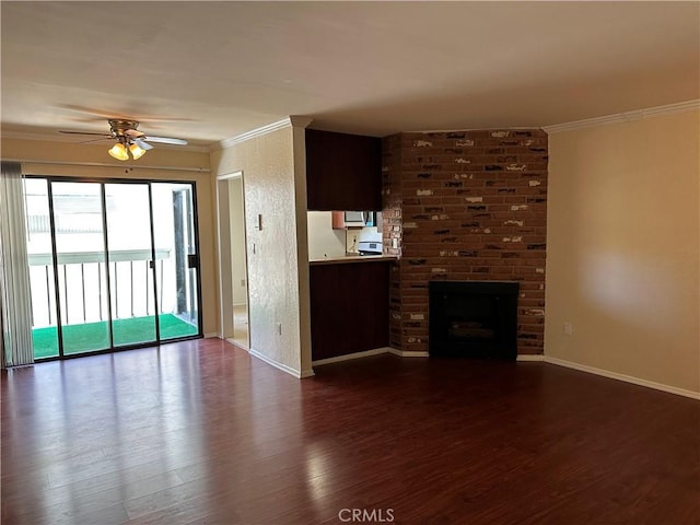 unfurnished living room featuring wood-type flooring, a brick fireplace, ceiling fan, and crown molding