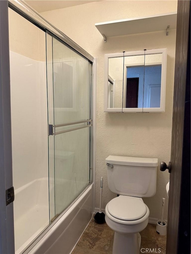 bathroom with combined bath / shower with glass door and toilet