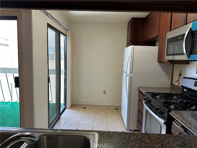 kitchen with light tile patterned floors and stainless steel appliances