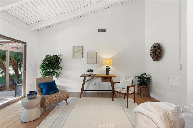 sitting room featuring vaulted ceiling with beams, light hardwood / wood-style flooring, and wood ceiling