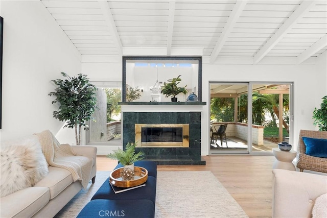 sunroom featuring a tiled fireplace, wood ceiling, and vaulted ceiling with beams